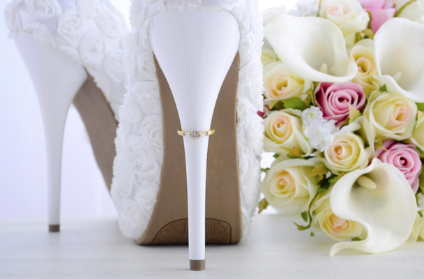 Ehering auf schönem weißen Stiletto-Schuhabsatz.  - Foto, Bild