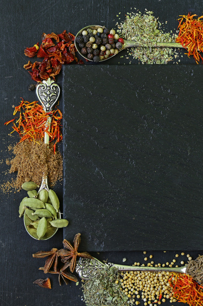Διάφορα μπαχαρικά σε μαύρο φόντο (πάπρικα, κουρκούμη, πιπέρι, γλυκάνισο, κανέλα, σαφράν) - Φωτογραφία, εικόνα