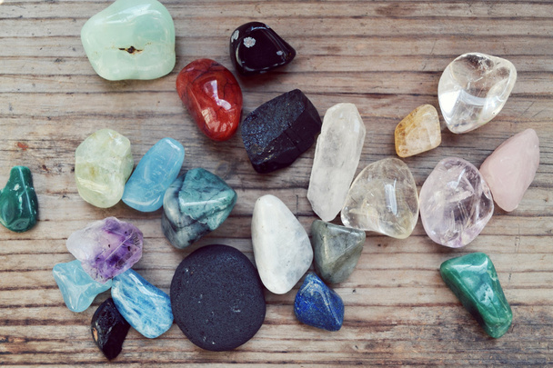 Diferentes pedras preciosas coloridas na mesa de madeira
 - Foto, Imagem