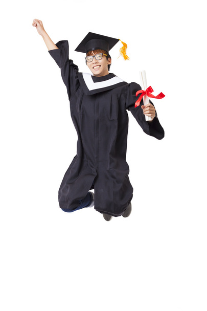 Happy student v Postgraduální šaty skákání proti Bílému pozadí - Fotografie, Obrázek