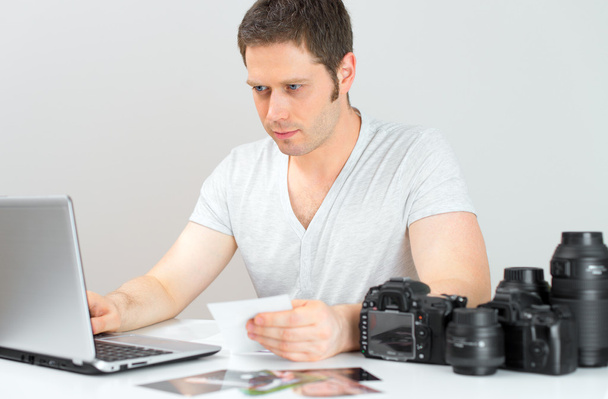 Fotógrafo seleccionando fotos en su ordenador
. - Foto, Imagen