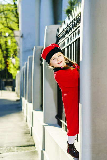 Cute little girl dressed in old-style coat posing on the street - Fotó, kép