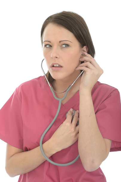 красива жінка лікар в рожевий театр Scrubs прослуховування її серце
 - Фото, зображення