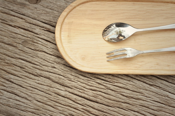 Cuchara y tenedor sobre un fondo de madera marrón
. - Foto, imagen