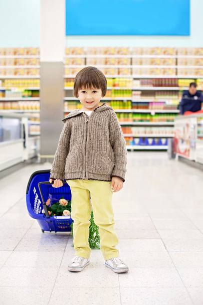 Cute little and proud boy helping with grocery shopping, healthy - Foto, Bild