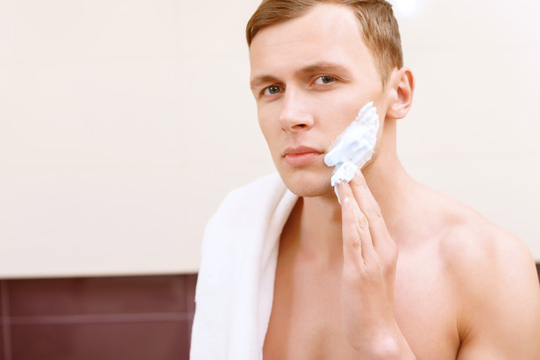 Topless man applying mean of shaving on face - Foto, Imagem