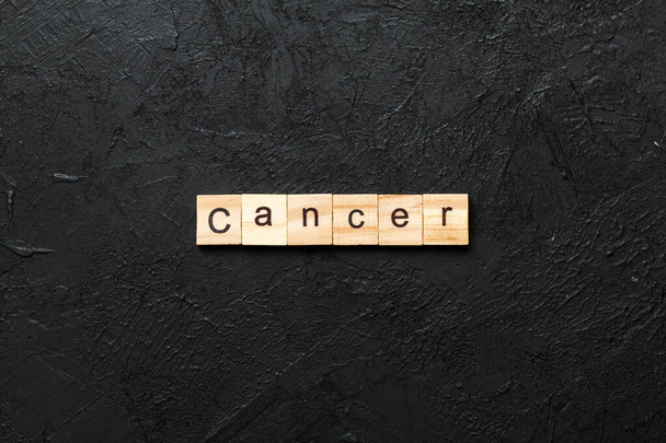 木製のブロックに書かれた癌の単語。あなたの設計、概念のためのセメントテーブルの癌のテキスト. - 写真・画像