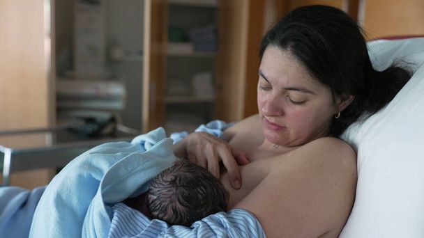 First Time Breastfeeding - New Mother Nurturing Newborn at Hospital Clinic After Childbirth - Photo, Image