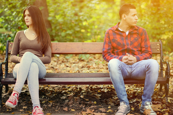Young couple in quarrel sitting on bench in park - Foto, Bild