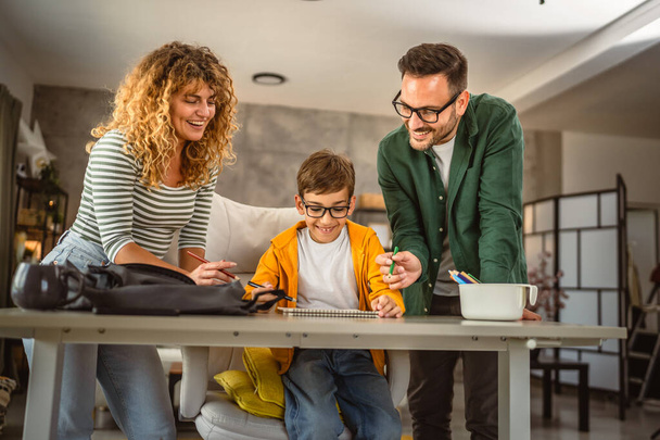 Onnellinen kolmen perhe vetää yhteen paperilla kotona - Valokuva, kuva