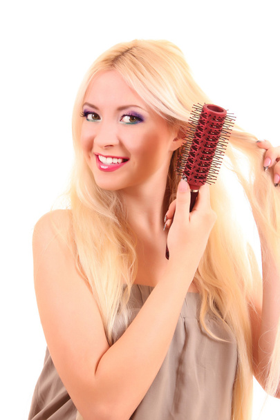 Beautiful young blonde woman brushing her long hair - Zdjęcie, obraz