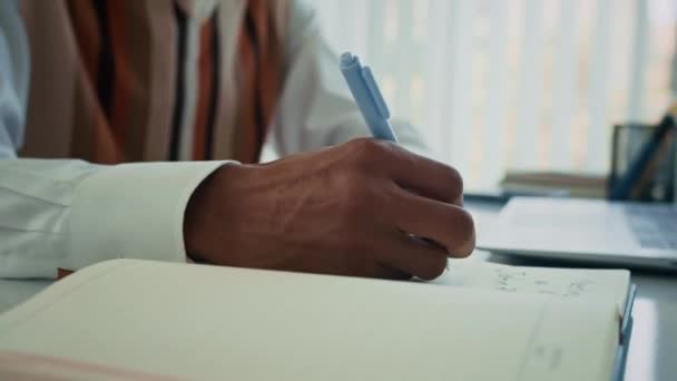 Schnappschuss der Hände eines nicht wiedererkennbaren Geschäftsmannes, der Plan für die Realisierung des Projekts schreibt und am Schreibtisch am Laptop arbeitet - Filmmaterial, Video