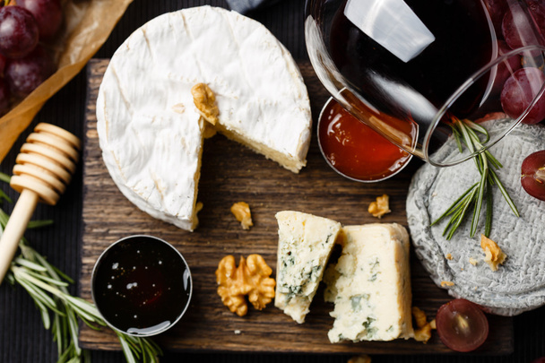 Assiette au fromage servie avec vin, confiture et miel
 - Photo, image