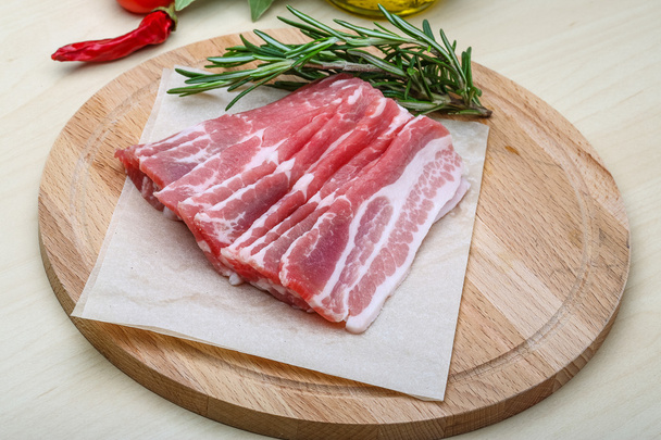 Sliced bacon with rosemary - Фото, зображення