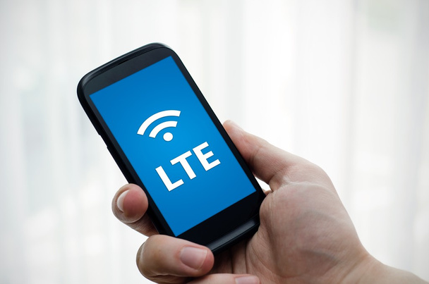 Рука держит мобильный телефон с LTE технологии быстрого интернета
 - Фото, изображение