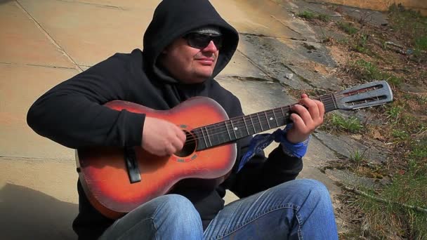 Человек играет на гитаре на открытом воздухе
 - Кадры, видео