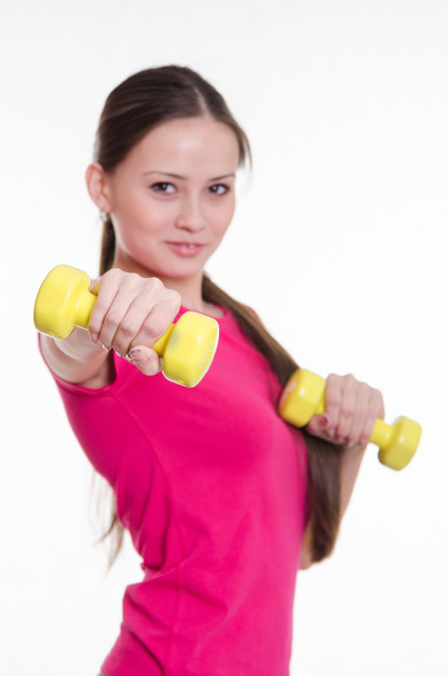 Sportswoman with two dumbbells in the hands of - Photo, Image