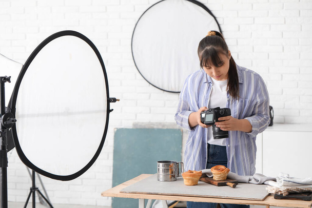 Femme photographe alimentaire prenant des photos de gâteaux savoureux en studio - Photo, image