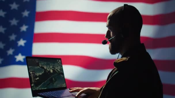 Despachador de la Fuerza Aérea de los Estados Unidos mirando la transmisión de vigilancia en el dispositivo, transmitiendo datos a soldados de tierra desde la sala de control usando auriculares, aislados sobre el fondo de la bandera de los Estados Unidos, cámara B - Imágenes, Vídeo