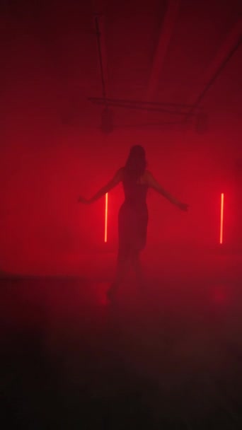 Sexy Frau in schwarzem Kleid tanzt Latein in rotem Neonlicht. Konzept von Tanz und Choreographie. Vertikales Video 4k - Filmmaterial, Video