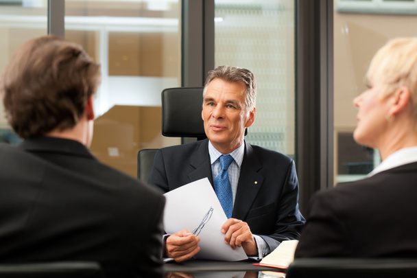 Advocaat of notaris met klanten in zijn kantoor - Foto, afbeelding