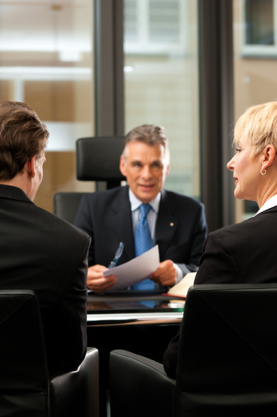 Advocaat of notaris met klanten in zijn kantoor - Foto, afbeelding