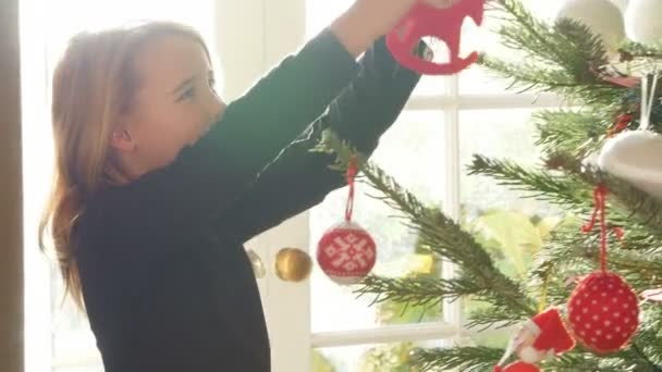 Girl decorating christmas tree - Filmagem, Vídeo