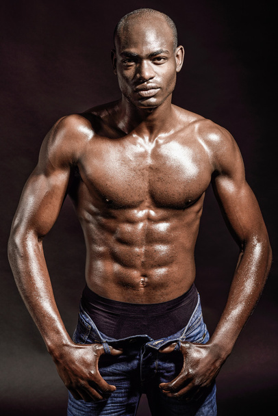 Athletic black man on black background - Foto, afbeelding