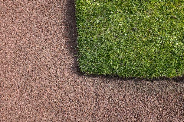 Coin de pelouse verte adjacent au sentier de tarmacadam rouge
 - Photo, image