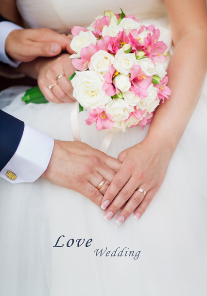 Wedding couple holding hands with a bouquet of flowers - Photo, Image