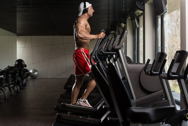 Mature Man Doing Aerobics Elliptical Walker In Gym - Photo, Image