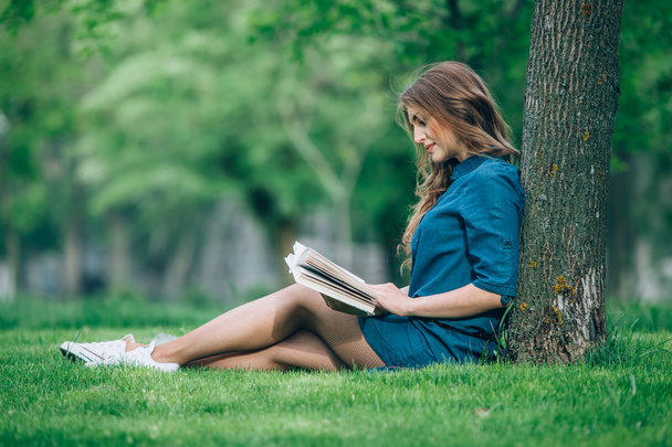 Girl reading a book in park - Fotografie, Obrázek