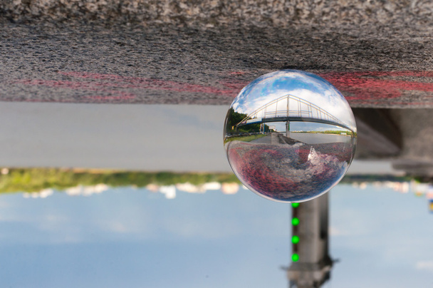 Szkło przejrzyste piłkę na tle mostu i ziarniste powierzchni. Z pustej przestrzeni - Zdjęcie, obraz