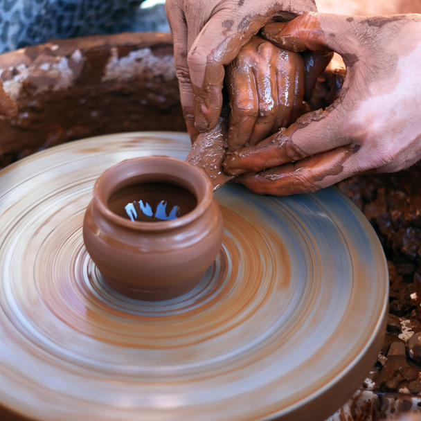 Mãos a trabalhar na roda de cerâmica
 - Foto, Imagem
