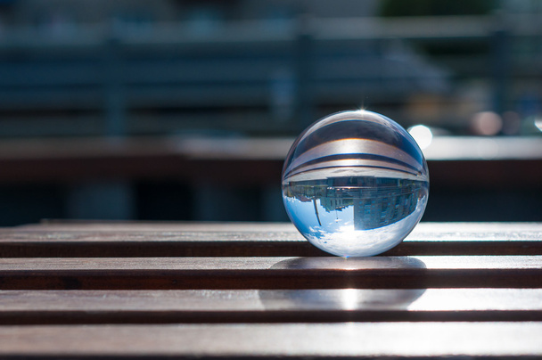 Glass transparent ball on wooden slats background. With empty space - Φωτογραφία, εικόνα