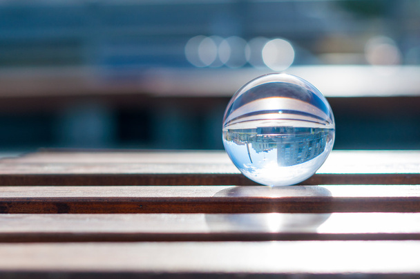 Bola transparente de vidro no fundo ripas de madeira. Com espaço vazio
 - Foto, Imagem