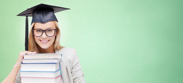 happy student in mortar board cap with books - Foto, Imagem