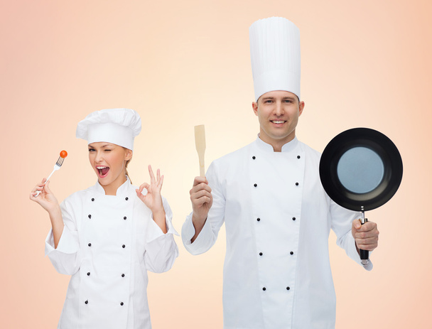 cocineros felices o pareja de cocineros con utensilios de cocina
 - Foto, Imagen