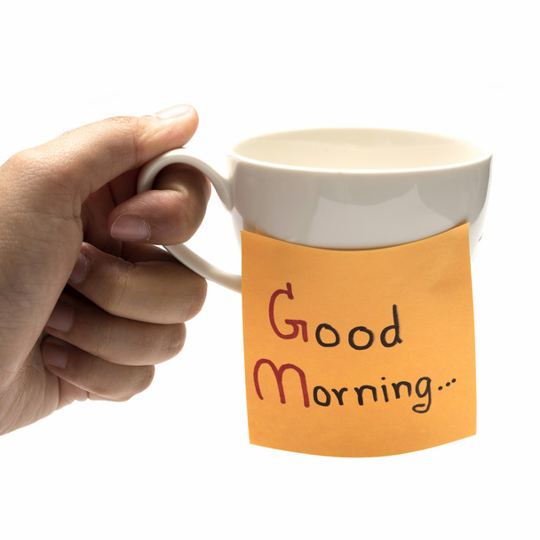 Hand haltende Kaffeetasse mit klebrigem Zettel Guten Morgen - Foto, Bild