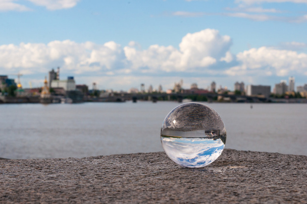 Γυάλινα διαφανή μπάλα σε φόντο πόλης και κοκκώδη επιφάνεια. Με κενό χώρο - Φωτογραφία, εικόνα