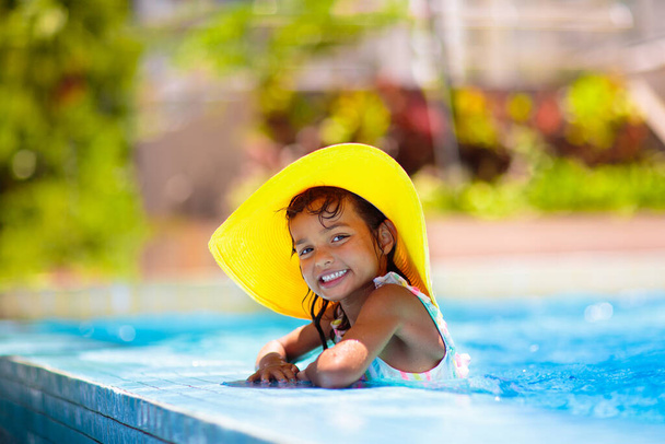 Little girl in swimming pool. Child learning to swim in outdoor pool of tropical resort. Water fun for baby and toddler. Travel with kids. Summer family vacation. Beach holiday with young kid.   - Photo, Image