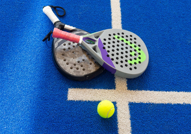 Pádlo tenis: Paddel raketa a míč před venkovní hřiště. Kvalitní fotografie - Fotografie, Obrázek