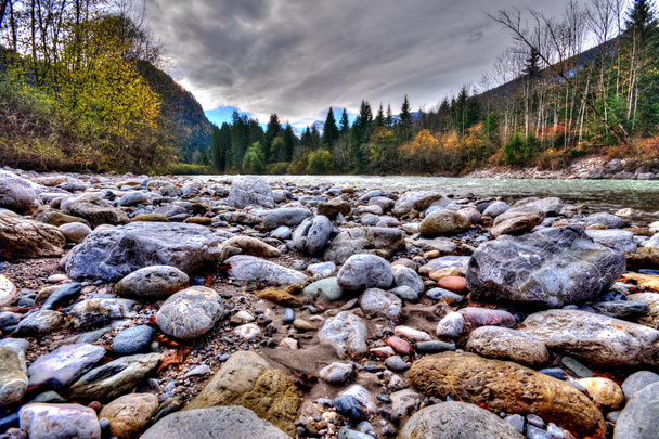 Rocks in the flowing river at the mountains - Photo, Image