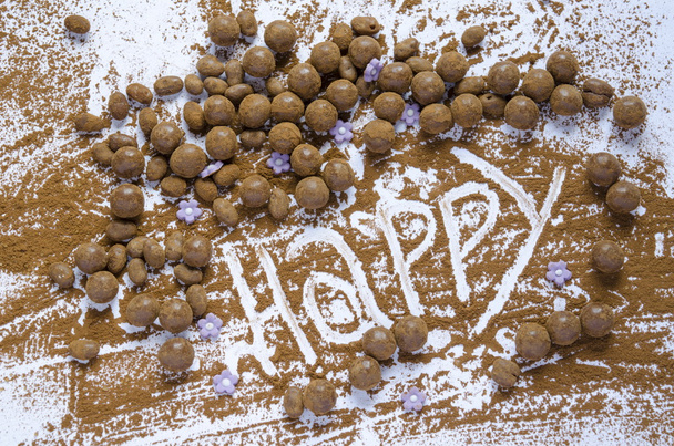 Bolas de chocolate em uma mesa com a palavra Feliz
 - Foto, Imagem
