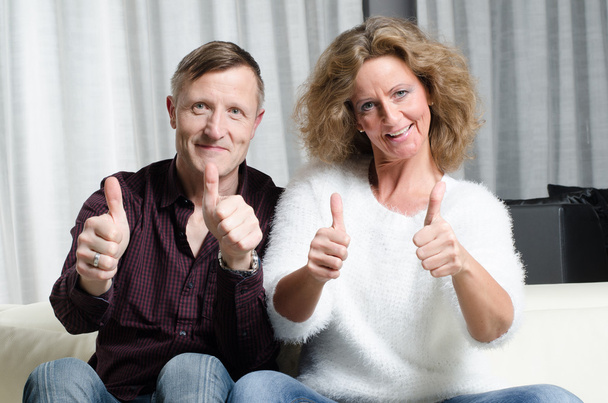 Couple on couch with thumbs up - Photo, Image