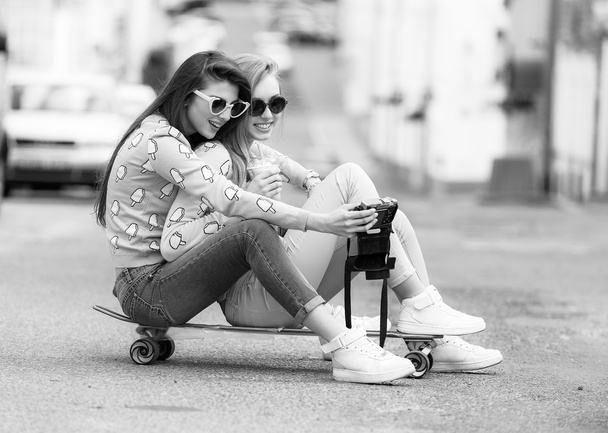 Hipster girlfriends taking a selfie in urban city context - Concept of friendship and fun with new trends and technology - Best friends eternalizing the moment with camera - Photo, Image