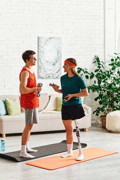 Un couple s'entraîne ensemble à la maison, une femme avec une jambe prothétique. - Photo, image