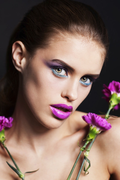 Beautiful young woman with professional make up with pink and white flowers - Foto, Imagen