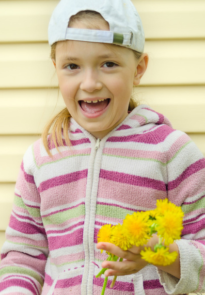 het jonge meisje doet een krans van gele bloemen van een paardenbloem - Foto, afbeelding
