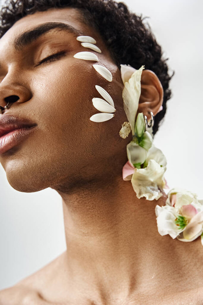 Um jovem afro-americano posa com flores, criando uma imagem marcante de beleza e diversidade. - Foto, Imagem